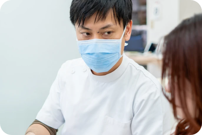 マスクをつけて患者さんと向き合う院長