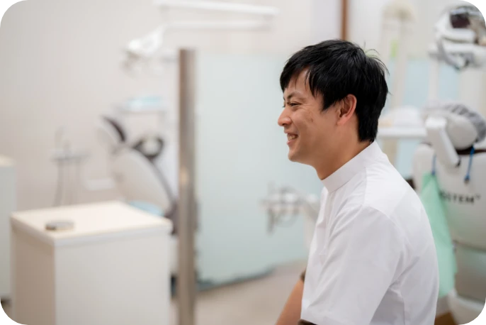 診療室で笑顔を見せる院長